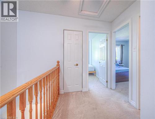 Corridor with light colored carpet, a textured ceiling, attic access, and an upstairs landing - 310 Christopher Drive Unit# 15, Cambridge, ON - Indoor Photo Showing Other Room