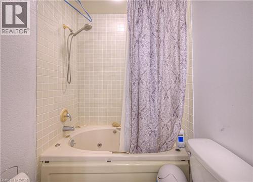 Bathroom with shower / bathtub combination with curtain and a textured wall - 310 Christopher Drive Unit# 15, Cambridge, ON - Indoor Photo Showing Bathroom