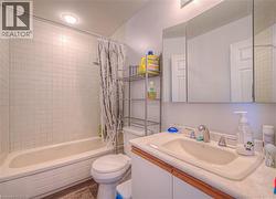 Bathroom featuring shower / bath combo, vanity, and wood finished floors - 