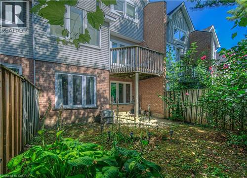 Rear view of house featuring a fenced backyard, a patio area, and brick siding - 310 Christopher Drive Unit# 15, Cambridge, ON - Outdoor With Balcony