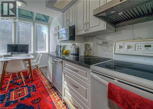 Kitchen appliances, exhaust hood, tasteful backsplash, dark wood-type flooring, and white cabinetry - 310 Christopher Drive Unit# 15, Cambridge, ON - Indoor Photo Showing Kitchen