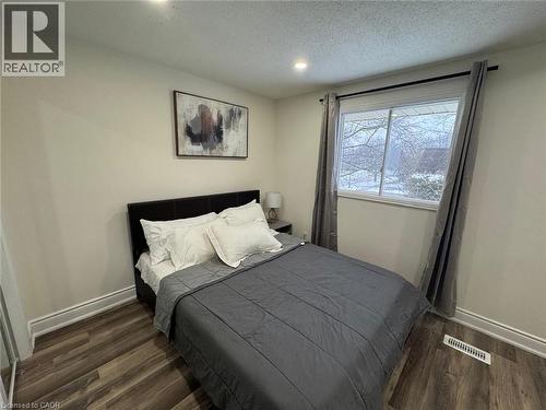 Bedroom featuring dark wood-type flooring, a textured ceiling, and recessed lighting - 389 Dunvegan Drive, Waterloo, ON - Indoor Photo Showing Bedroom