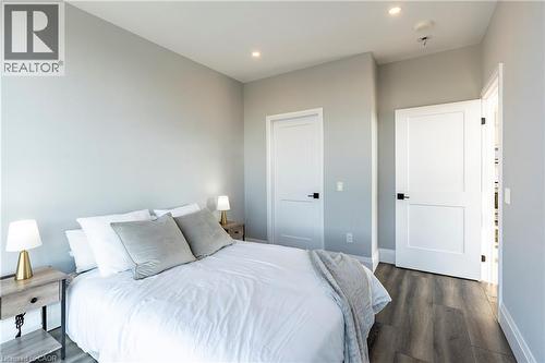 Bedroom featuring dark wood-style flooring and recessed lighting - 60 Charles Street W Unit# 705, Kitchener, ON - Indoor Photo Showing Bedroom