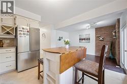 Kitchen with freestanding refrigerator, a kitchen breakfast bar, and light tile patterned floors - 