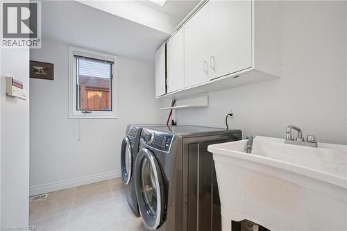 Washroom with cabinet space, light tile patterned floors, and washing machine and clothes dryer - 599 Beechwood Drive, Waterloo, ON - Indoor Photo Showing Laundry Room