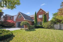 View of front of property with brick siding, asphalt driveway, and a garage - 
