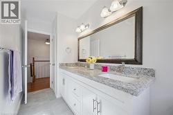 Bathroom featuring double vanity and light tile patterned floors - 