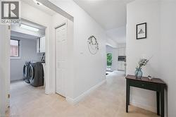 Hall featuring washing machine and dryer, light tile patterned floors, and a textured ceiling - 