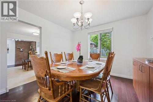 Dining area with dark wood-style flooring and a chandelier - 599 Beechwood Drive, Waterloo, ON - Indoor Photo Showing Dining Room