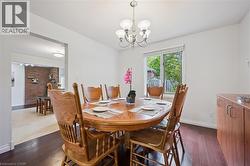 Dining area with dark wood-style flooring and a chandelier - 