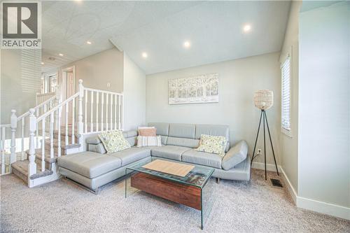 Carpeted living area with lofted ceiling, recessed lighting, and stairway - 220 Sienna Crescent, Kitchener, ON - Indoor Photo Showing Living Room
