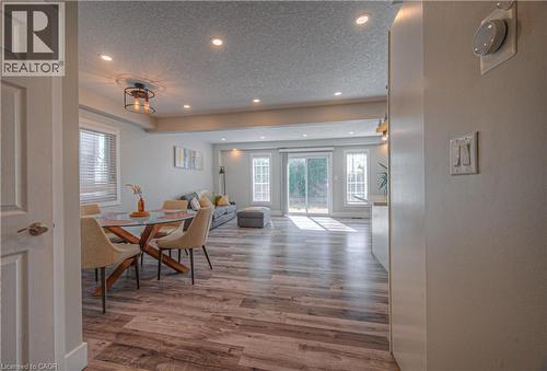Dining area with a textured ceiling, light wood finished floors, recessed lighting, and plenty of natural light - 220 Sienna Crescent, Kitchener, ON - Indoor