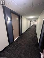 Hall with a paneled ceiling and carpet flooring - 