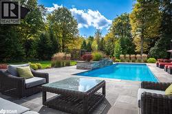 Outdoor pool featuring a patio area and an outdoor living space - 