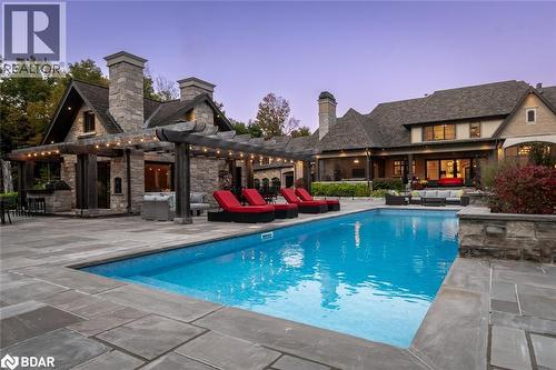 Pool at dusk with an outdoor pool, a patio, and a pergola - 13160 Nassagaweya Esquesing Townline, Milton, ON - Outdoor With In Ground Pool With Deck Patio Veranda