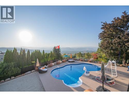 View of salt water pool from deck - 702 Cypress Drive, Coldstream, BC - Outdoor With In Ground Pool