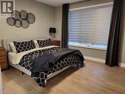 Bedroom featuring light wood-style floors and baseboards - 