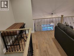 Hall featuring light wood-style flooring and an upstairs landing - 