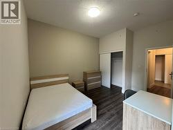 Bedroom with a textured ceiling, dark wood-style flooring, and a closet - 