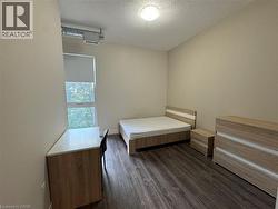 Bedroom with dark wood-type flooring and a textured ceiling - 