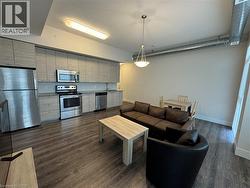 Living area featuring baseboards and dark wood-style floors - 