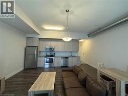 Living area featuring dark wood-style floors and baseboards - 