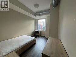 Bedroom with dark wood-style floors and an office area - 