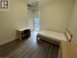 Bedroom featuring dark wood finished floors and baseboards - 