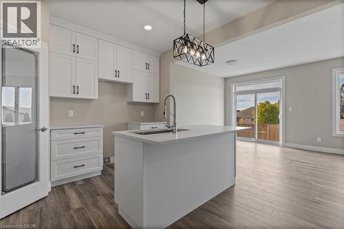 Kitchen with white cabinetry, dark wood finished floors, recessed lighting, decorative light fixtures, and a center island with sink - 256 Keeso Lane, Listowel, ON - Indoor Photo Showing Kitchen