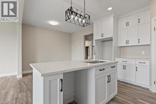 Kitchen with hanging light fixtures, a kitchen island with sink, light wood-style floors, white cabinets, and recessed lighting - 256 Keeso Lane, Listowel, ON - Indoor Photo Showing Kitchen