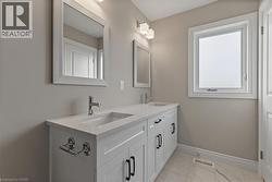 Full bathroom featuring double vanity and light marble finish flooring - 