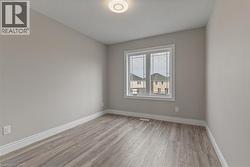 Unfurnished room featuring light wood finished floors and a textured ceiling - 