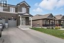 View of front facade featuring brick siding, asphalt driveway, a front lawn, a porch, and an attached garage - 256 Keeso Lane, Listowel, ON  - Outdoor With Facade 