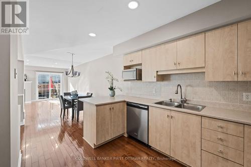 Tiled backsplash and breakfast bar seating. - 20 Fieldberry Private, Ottawa, ON - Indoor Photo Showing Kitchen With Double Sink