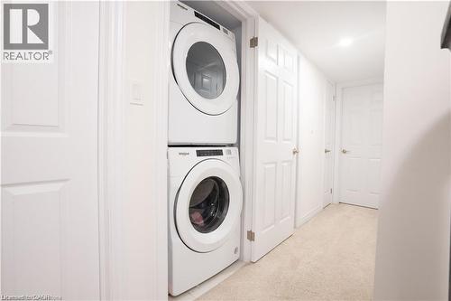 Washroom with light carpet and stacked washing machine and dryer - 85 Mullin Drive Unit# 20B, Guelph, ON - Indoor Photo Showing Laundry Room