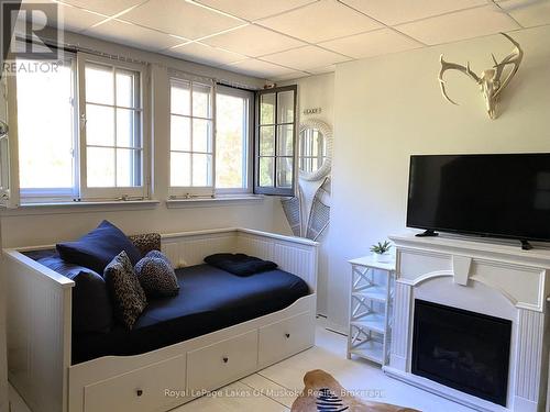 Interior of Unit  with view to Tennis/Pickle ball - 307 - 12 Bigwin Island Island, Lake Of Bays (Franklin), ON - Indoor Photo Showing Bedroom With Fireplace