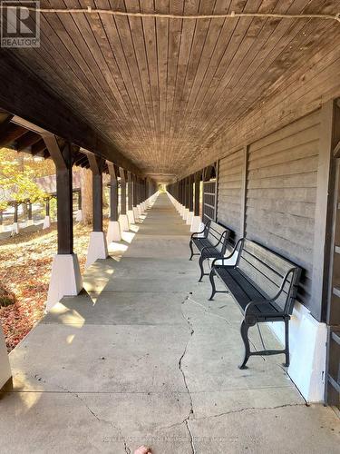 Covered walkway with benches. - 307 - 12 Bigwin Island Island, Lake Of Bays (Franklin), ON - Outdoor With Exterior