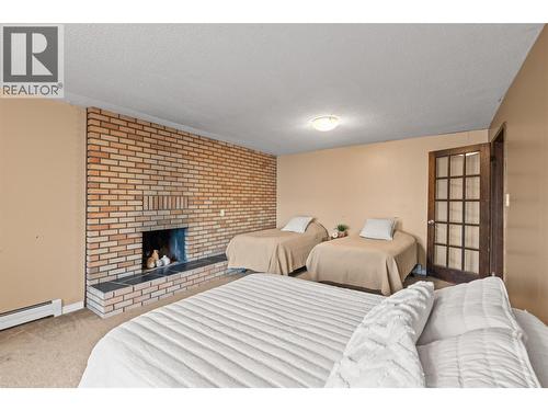 Living/Media Room in Walk Out Basement Used as Additional Bedroom - 8997 Peters Road, Vernon, BC - Indoor Photo Showing Bedroom With Fireplace