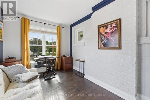 Den/Office Boasts a Painted Brick Accent Wall - 677 Greenwood Drive, Burlington, ON - Indoor Photo Showing Living Room