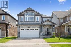 Craftsman-style home featuring stone siding, driveway, a garage, a front lawn, and board and batten siding - 