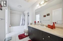 Full bath with vanity, tile patterned floors, and shower / tub combo - 