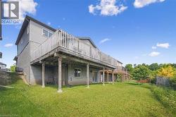 Back of property with a yard and a wooden deck - 