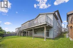 Back of house featuring a deck, brick siding, and stairs - 