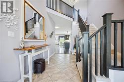 Tiled entrance foyer featuring stairs and a towering ceiling - 
