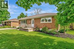 Single story home featuring a front yard and brick siding - 