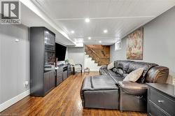 Living room featuring dark wood-style floors, wooden ceiling, stairs, and recessed lighting - 
