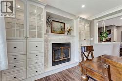 Living area with a fireplace, dark wood finished floors, recessed lighting, and ornamental molding - 