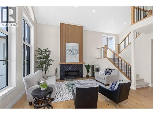 Large open living room with slat wall fireplace - 4964 Bucktail Lane, Kelowna, BC - Indoor Photo Showing Living Room With Fireplace