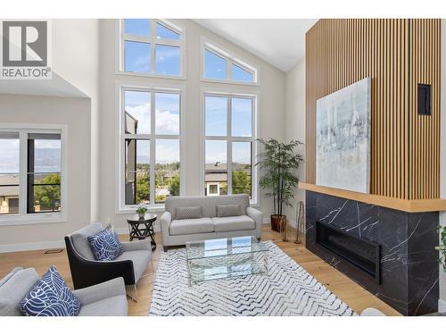 Abundance of natural light with large windows. - 4964 Bucktail Lane, Kelowna, BC - Indoor Photo Showing Living Room With Fireplace