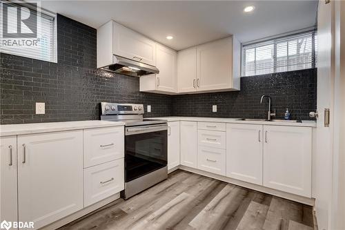 Kitchen featuring healthy amount of natural light, stainless steel electric range oven, backsplash, white cabinets, and recessed lighting - 22 St James Street Unit# C, Brantford, ON - Indoor Photo Showing Kitchen With Upgraded Kitchen